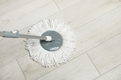 String mop on wooden floor, above view. Space for text