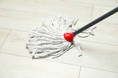 String mop on wooden floor. Cleaning equipment