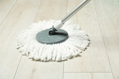 Photo of String mop on wooden floor. Cleaning equipment