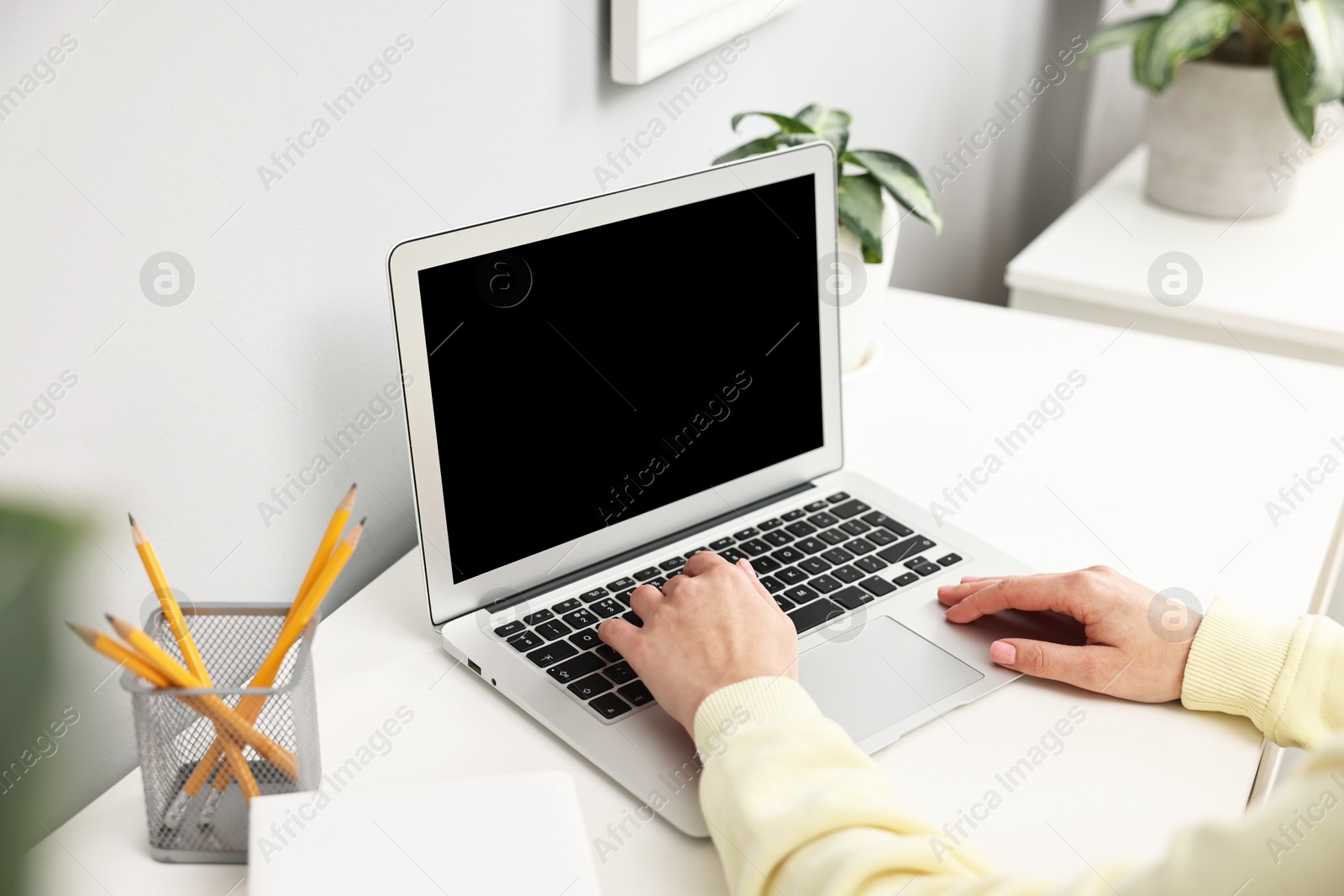 Photo of Woman working on computer at desk indoors, closeup