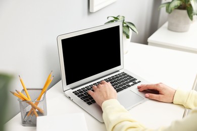 Photo of Woman working on computer at desk indoors, closeup