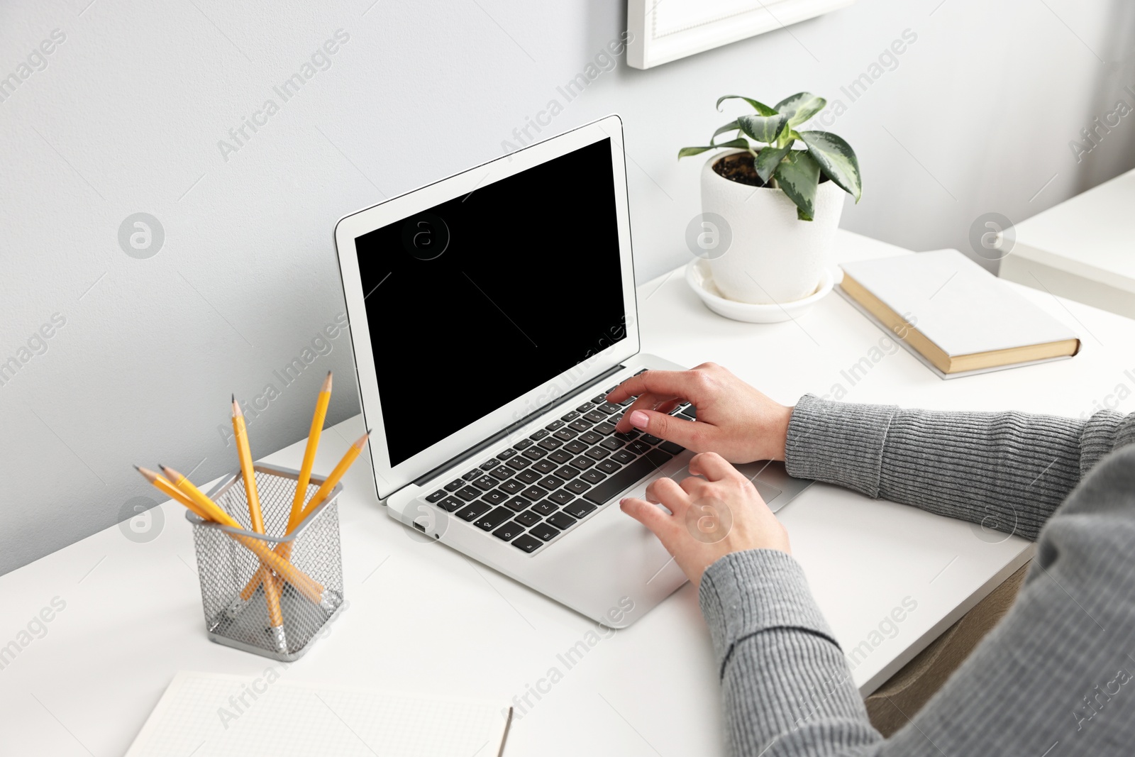 Photo of Woman working on computer at desk indoors, closeup