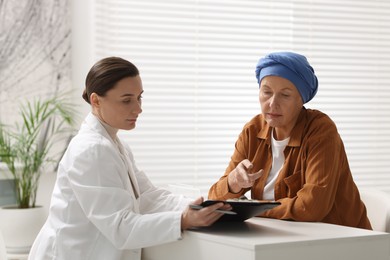 Photo of Senior woman with cancer visiting oncologist in clinic