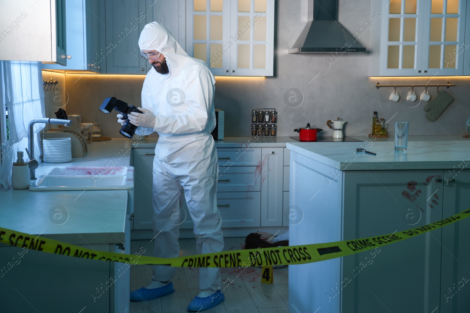 Photo of Forensic expert with camera working at crime scene in dark room