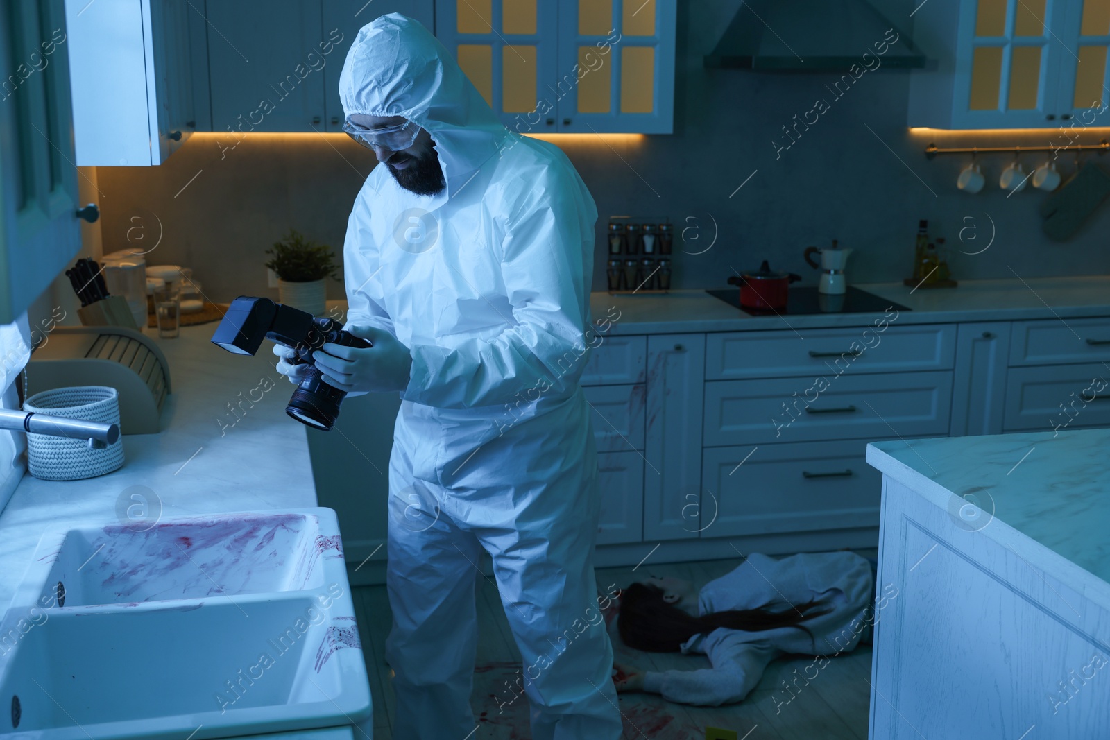 Photo of Forensic expert with camera working at crime scene in dark room