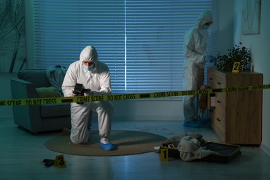 Photo of Forensic experts working at crime scene indoors