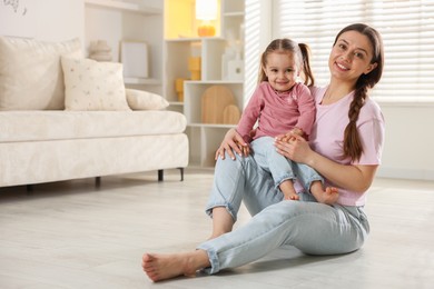 Photo of Happy mother with little daughter spending time together at home. Space for text