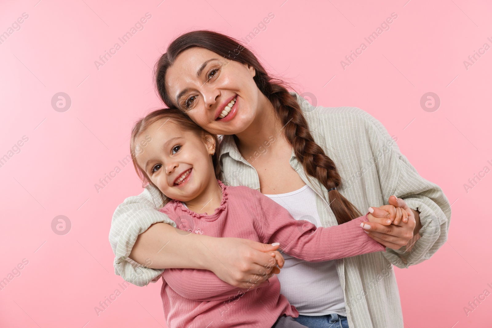 Photo of Family portrait of beautiful mother with little daughter on pink background