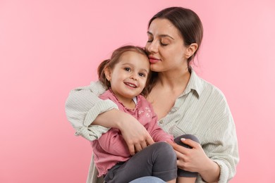 Photo of Portrait of mother with her cute daughter on pink background