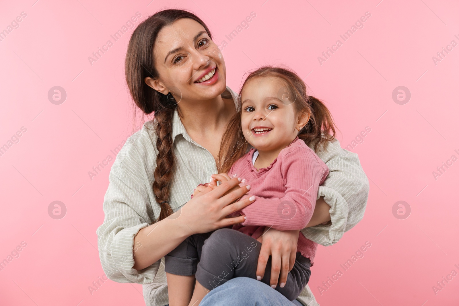 Photo of Portrait of mother with her cute daughter on pink background