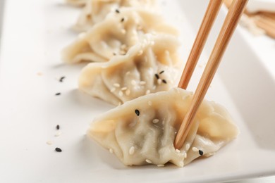 Photo of Eating tasty gyoza dumplings at table, closeup