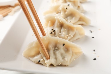 Photo of Eating tasty gyoza dumplings at table, closeup