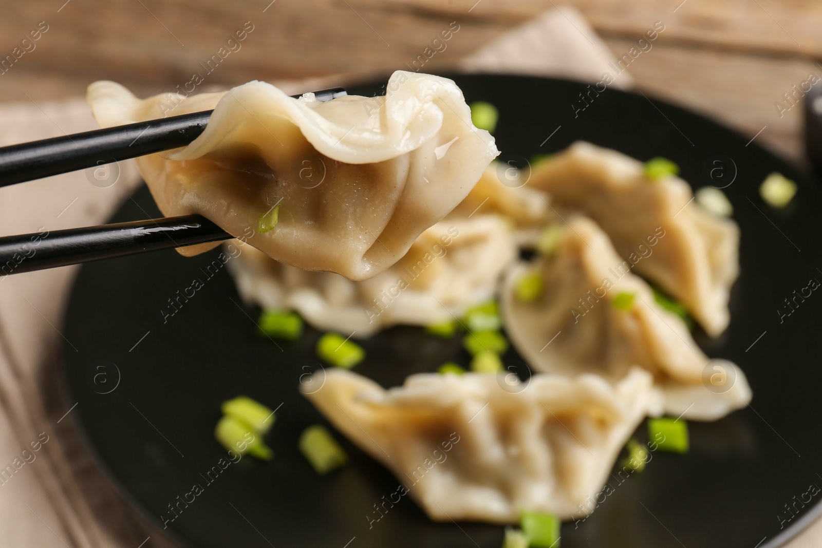 Photo of Eating tasty gyoza dumplings at table, closeup