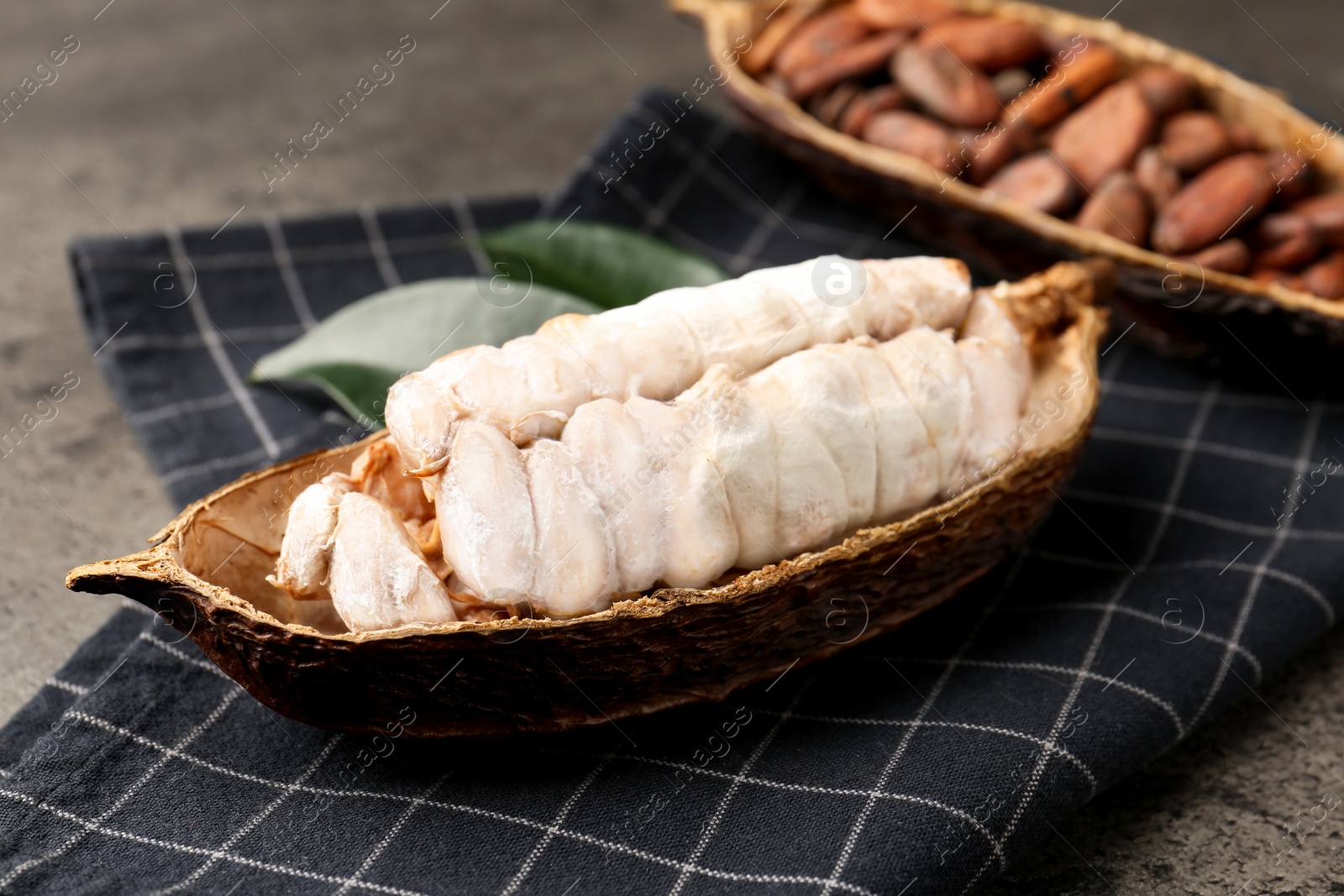 Photo of Cocoa pods with beans on grey table, closeup