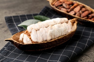 Cocoa pods with beans on grey table, closeup