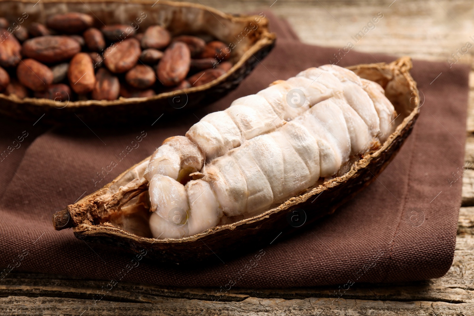 Photo of Cocoa pods with beans on wooden table, closeup