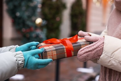 Photo of Friends with Christmas gift on city street, closeup