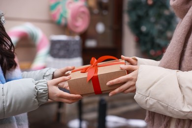 Photo of Friends with Christmas gift on city street, closeup