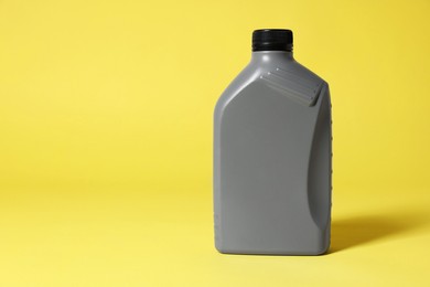 Photo of One grey plastic canister on yellow background, space for text