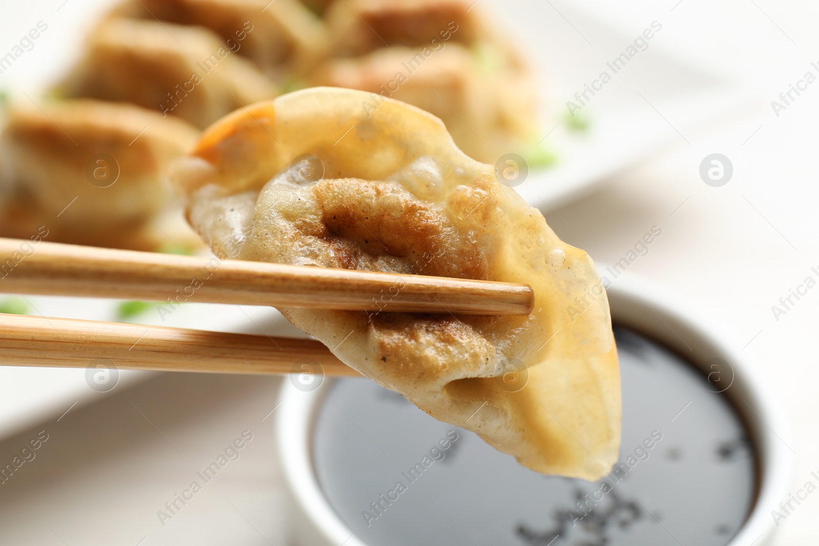 Photo of Eating fried gyoza dumplings at white table, closeup