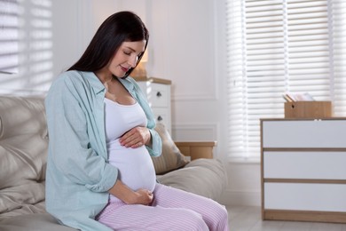 Photo of Beautiful pregnant woman on sofa at home