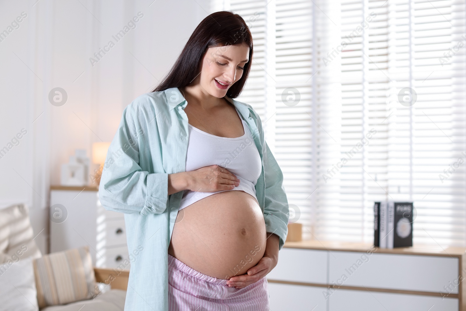 Photo of Beautiful pregnant woman with cute belly at home