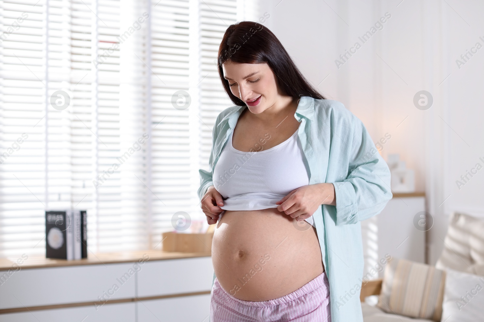 Photo of Beautiful pregnant woman with cute belly at home