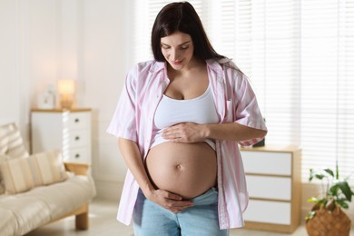 Photo of Beautiful pregnant woman with cute belly at home