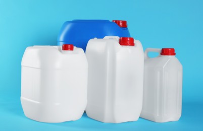 Photo of Different plastic canisters on light blue background