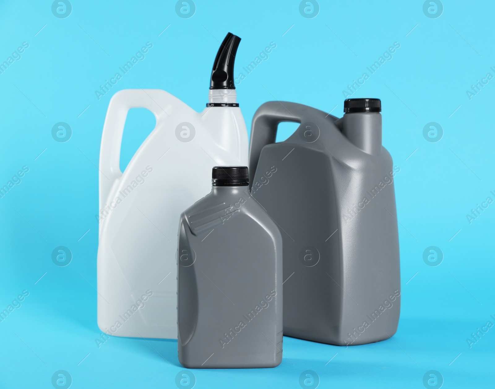 Photo of Different plastic canisters on light blue background