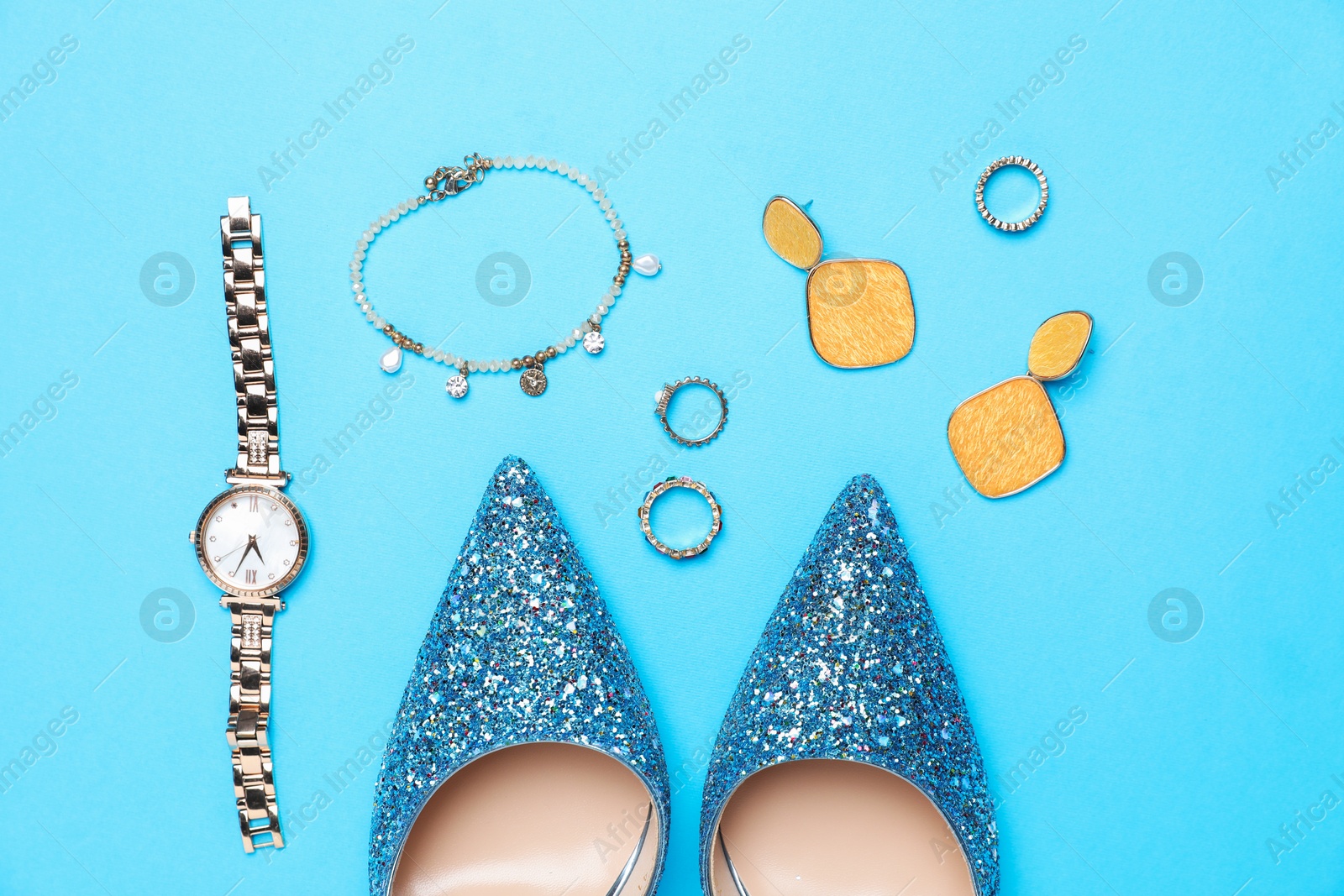 Photo of Beautiful shoes and stylish accessories on light blue background, flat lay