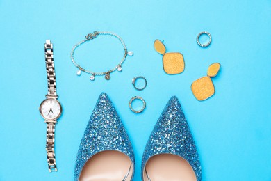 Beautiful shoes and stylish accessories on light blue background, flat lay