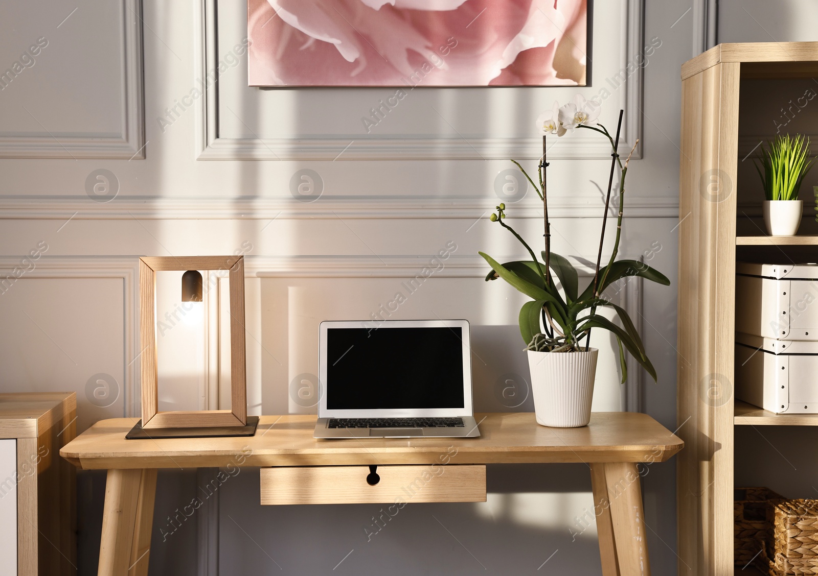 Comfortable workplace with modern laptop and lamp on wooden desk in home office Photo of Comfortable workplace with modern laptop and lamp on wooden desk in home office