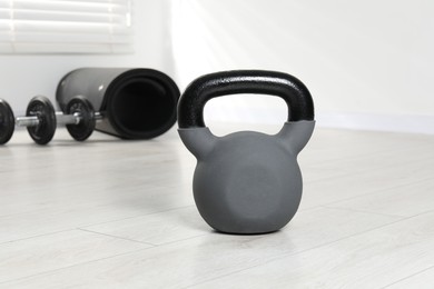 Photo of One heavy kettlebell on floor indoors. Sport equipment