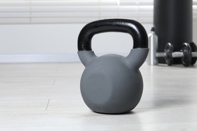 Photo of One heavy kettlebell on floor indoors, closeup