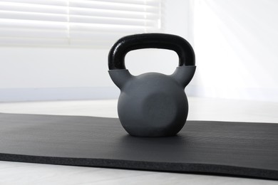 Photo of One kettlebell and mat on floor indoors