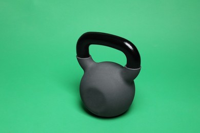 Photo of One heavy kettlebell on green background. Sport equipment