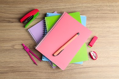 Photo of Doing homework. Notebooks and other different stationery on wooden table, flat lay