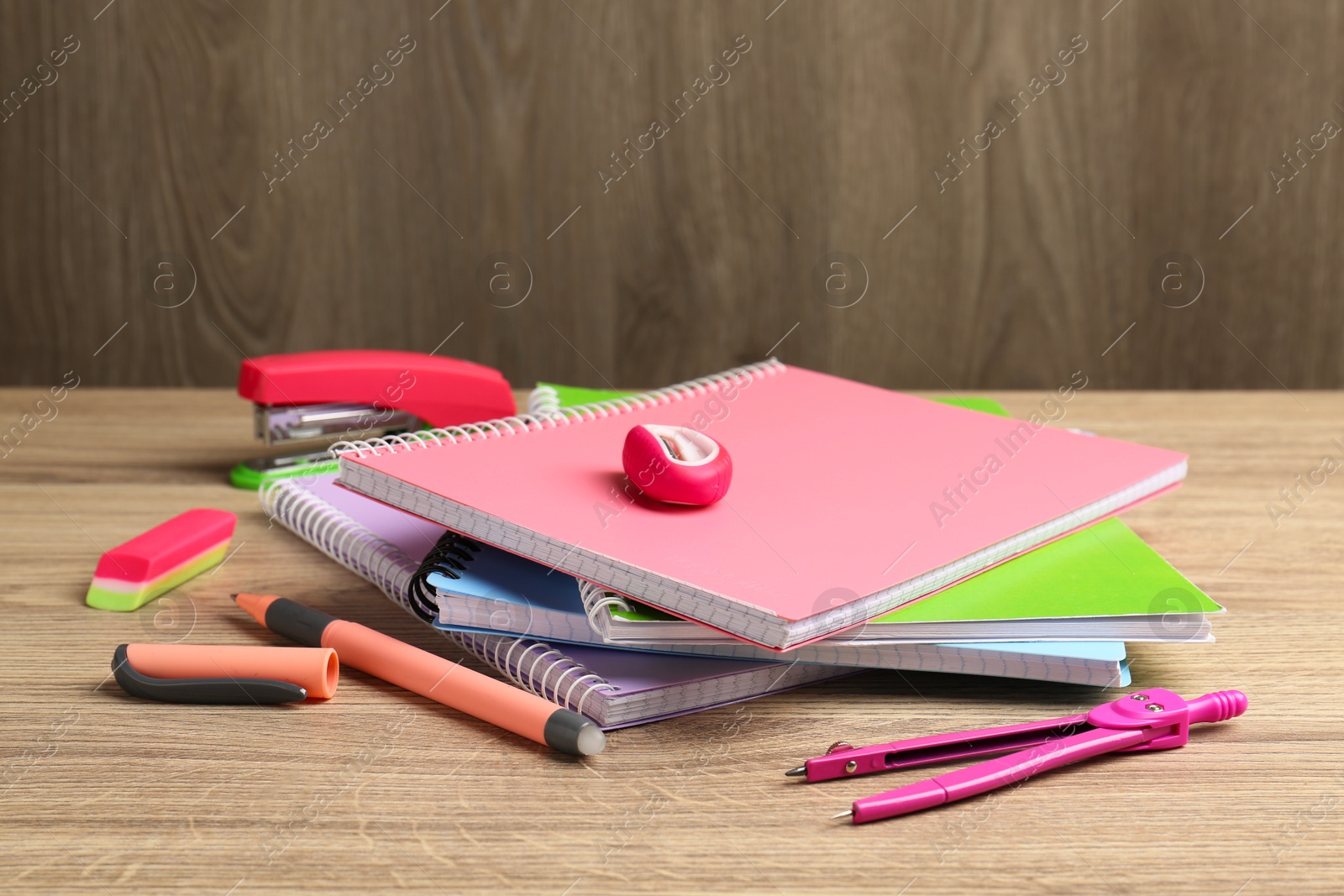 Photo of Doing homework. Notebooks and other different stationery on wooden table, closeup