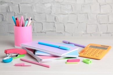 Photo of Doing homework. Notebooks and other different stationery on wooden table, closeup