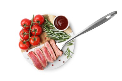 Photo of Delicious sliced beef tenderloin with different degrees of doneness, tomatoes, sauce and spices isolated on white, top view