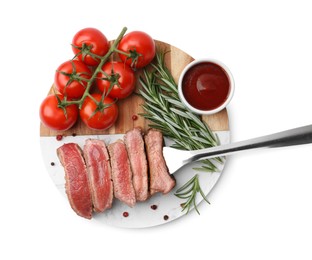 Photo of Delicious sliced beef tenderloin with different degrees of doneness, tomatoes, sauce and spices isolated on white, top view