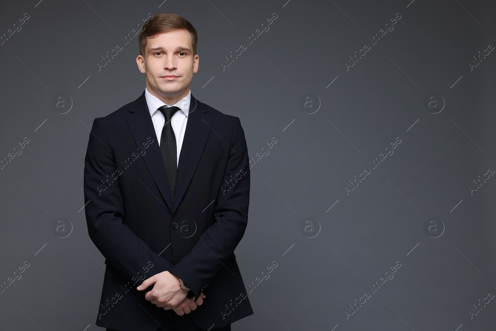 Photo of Man in classic suit on grey background. Space for text