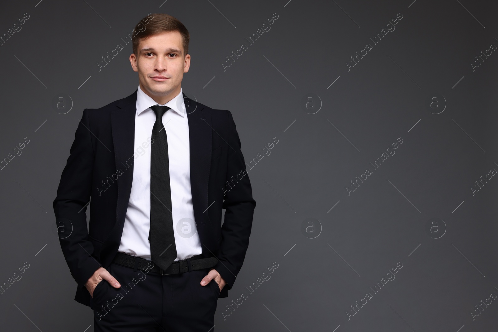 Photo of Man in classic suit on grey background. Space for text