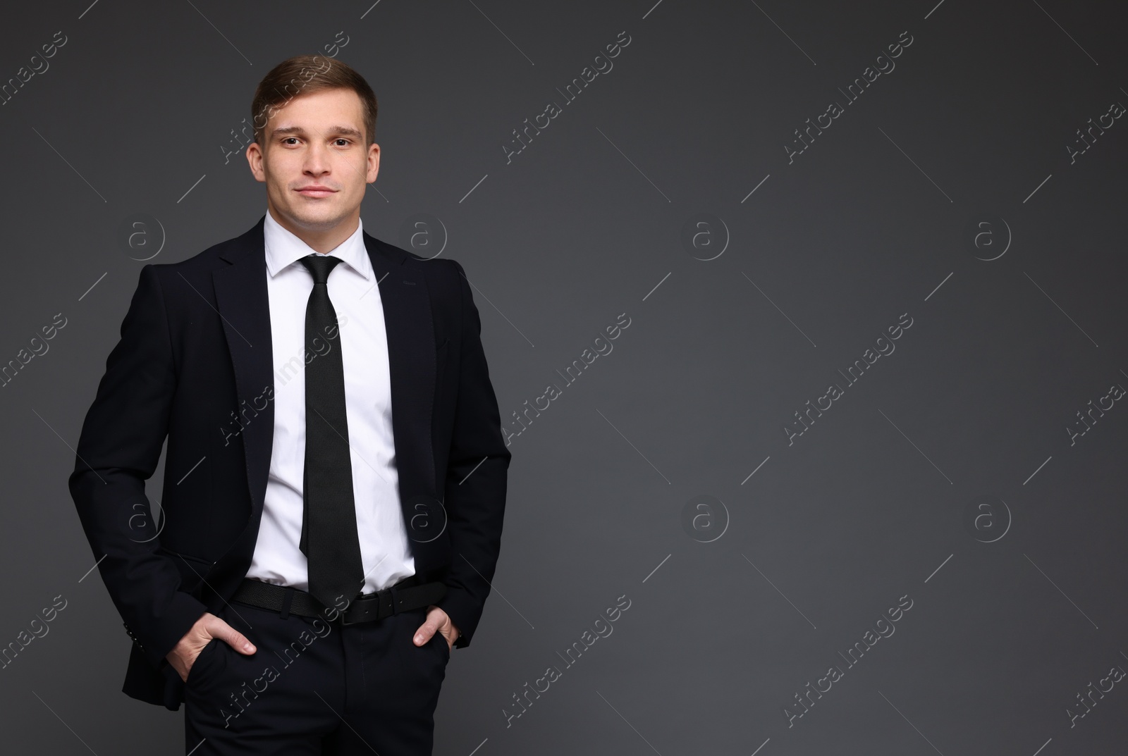 Photo of Man in classic suit on grey background. Space for text