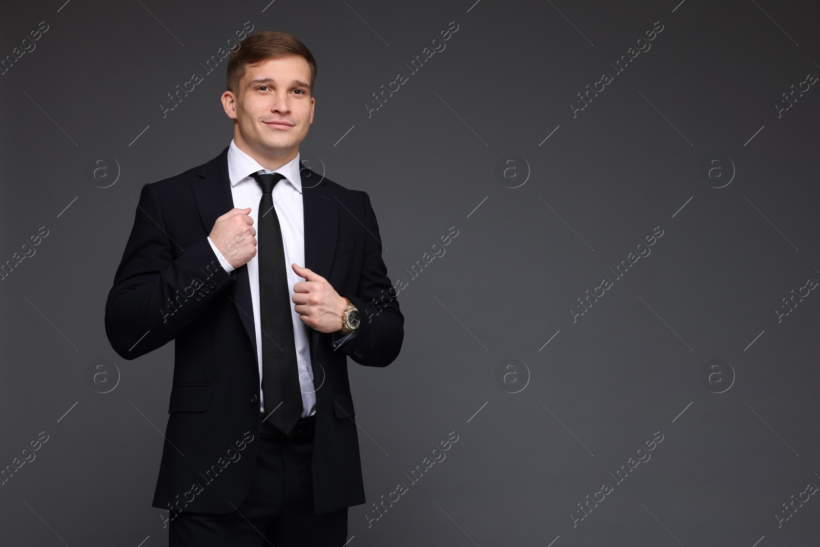 Photo of Man in classic suit with stylish watch on grey background. Space for text