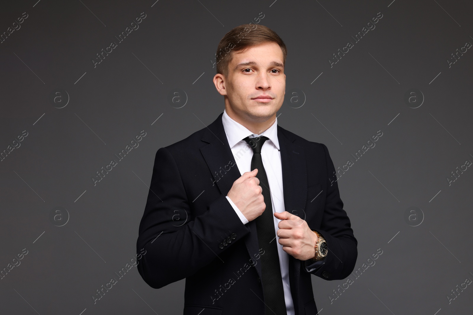 Photo of Man in classic suit with stylish watch on grey background