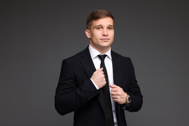 Photo of Man in classic suit with stylish watch on grey background