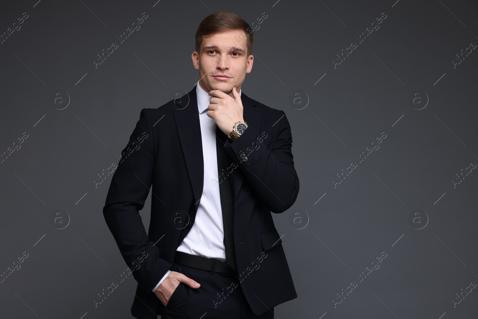 Photo of Man in classic suit with stylish watch on grey background