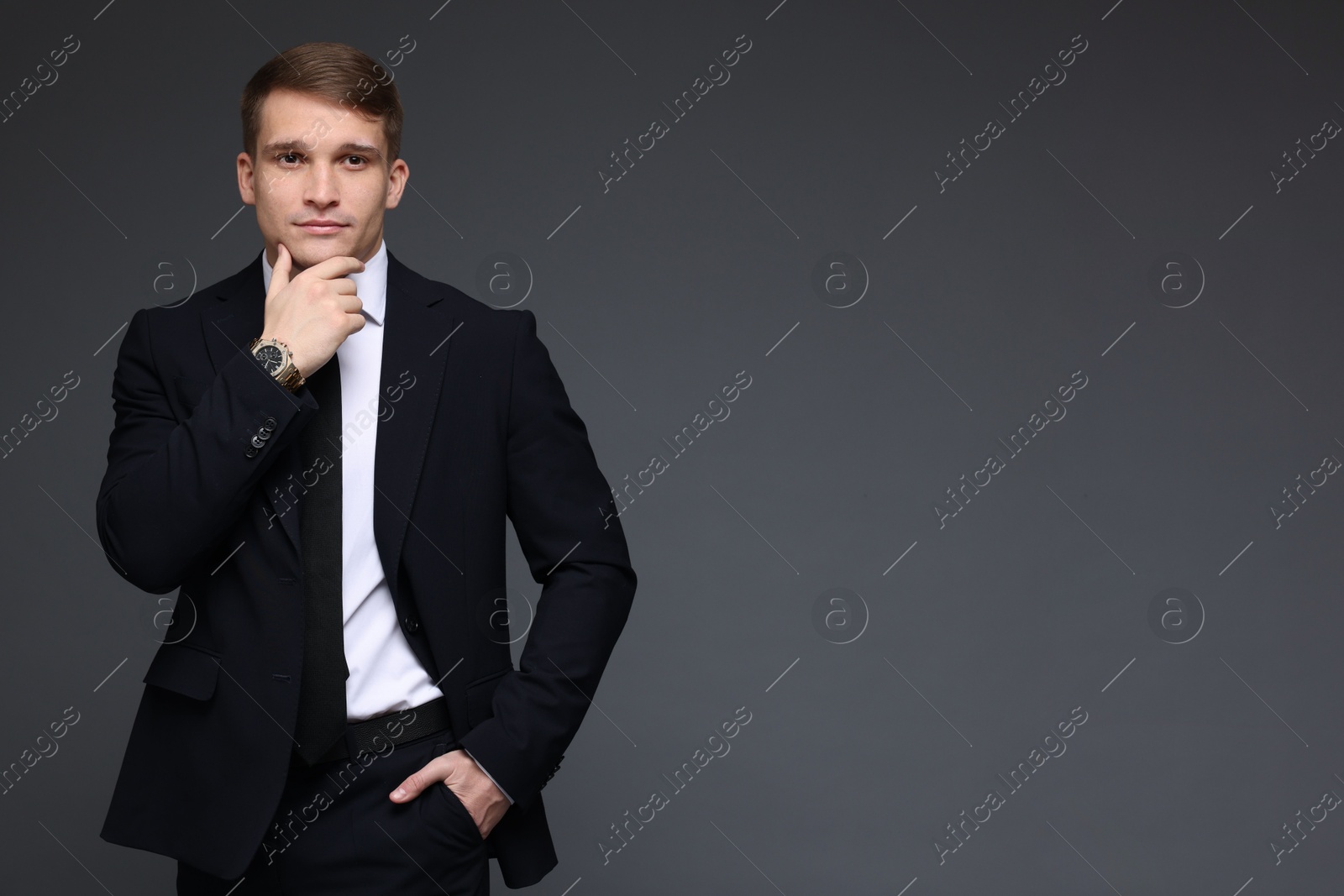 Photo of Man in classic suit with stylish watch on grey background. Space for text